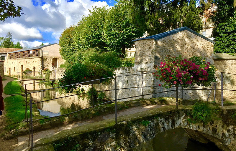 Viejo puente de piedra sobre un río angosto en el pueblo de Chevreuse, Ile de France