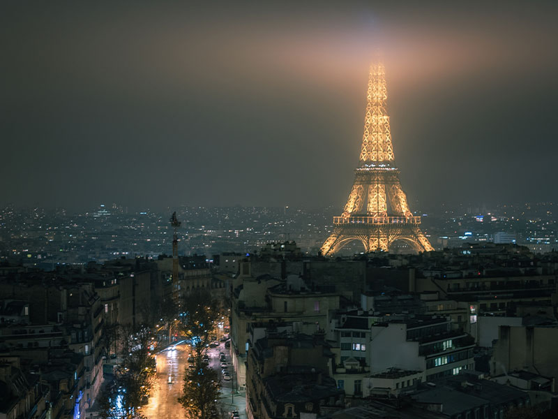 La cima de la Torre Eiffel devorada por la niebla en una noche invernal
