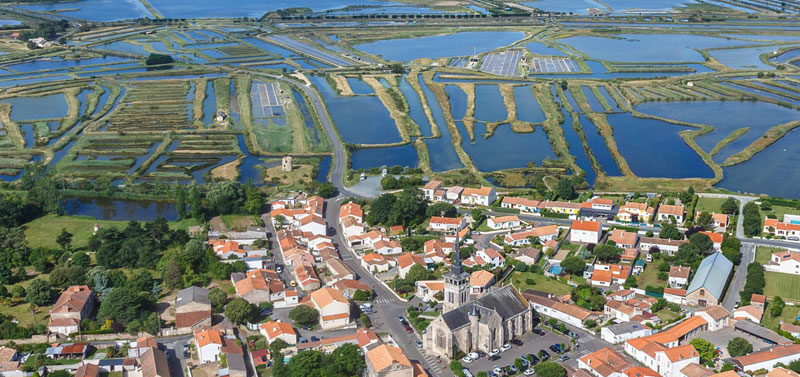 Enorme área de marismas en Les Sables d'Olonne, aguas azules separadas por caminos verdes cubiertos de hierba