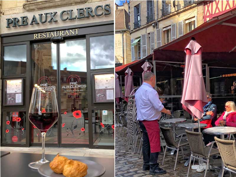 Camarero con delantal tradicional sirve vino en un bar en Dijon, Borgoña