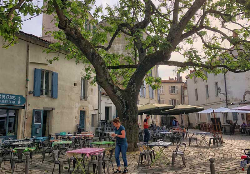 Pequeña plaza adoquinada llena de bonitos bares y restaurantes en La Rochelle