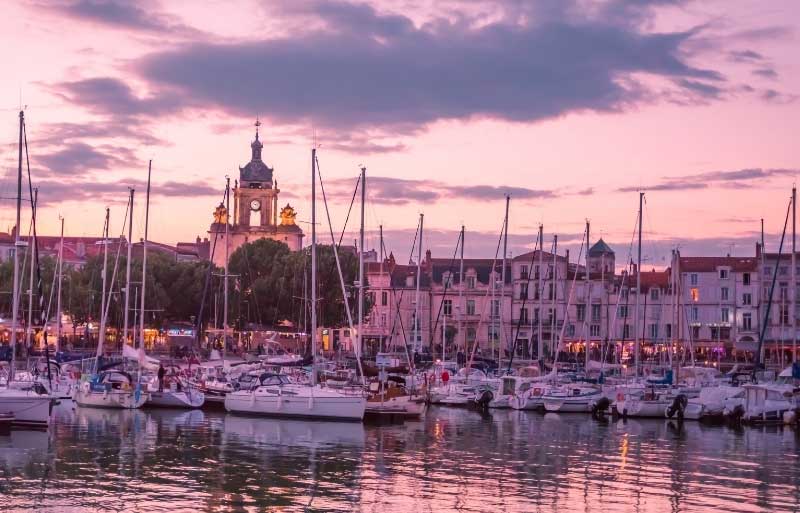 La Rochelle al anochecer, nubes teñidas de rosa sobre el casco antiguo