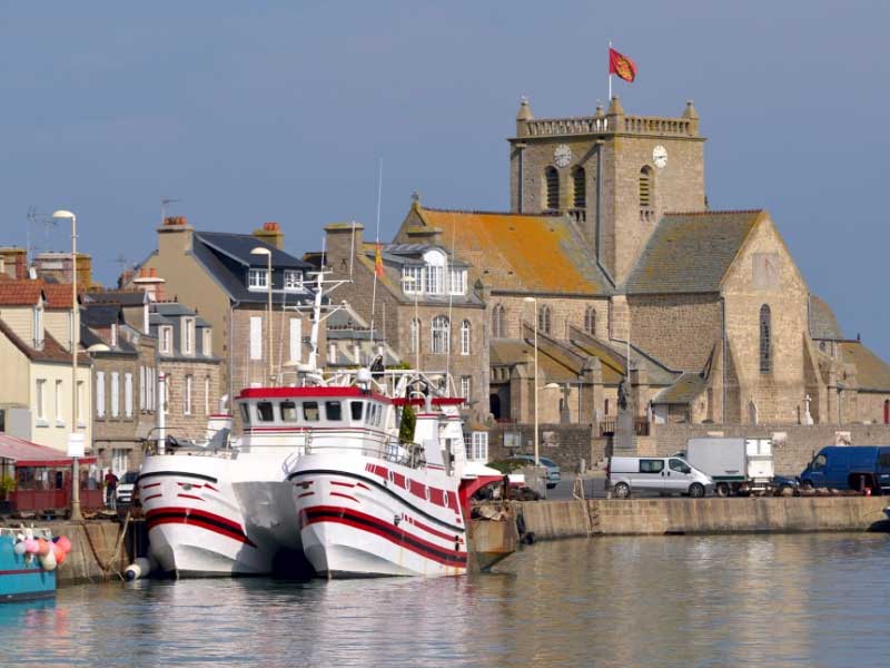 Bonita ciudad portuaria con coloridos barcos flotando en el puerto de Barfleur, Normandía