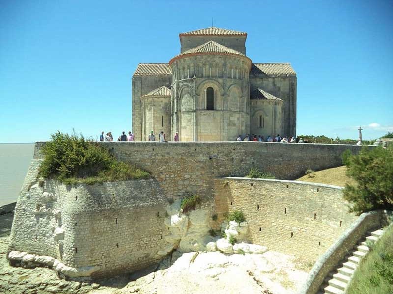 Iglesia de Sainte-Radegonde, Talmont-sur-Gironde, piedra blanca contra un cielo azul oscuro