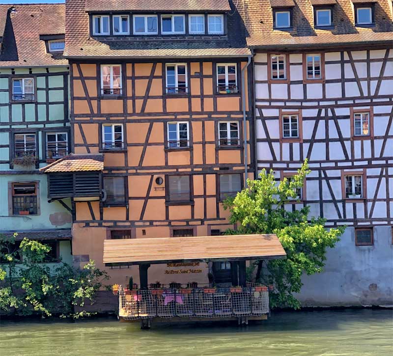 Coloridas casas medievales y un lavadero en el río convertido en un restaurante con terraza, Estrasburgo