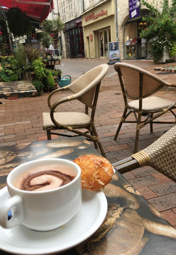 Taza de café en una mesa de un café con terraza en una calle adoquinada en el casco antiguo de Saintes, Charentes
