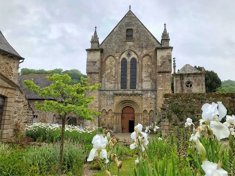 Abadía y jardines en León, flores brillantes contra piedra antigua