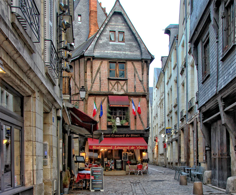 Histórica calle adoquinada en Tours con muchas casas con entramados de madera y coloridas tiendas y restaurantes