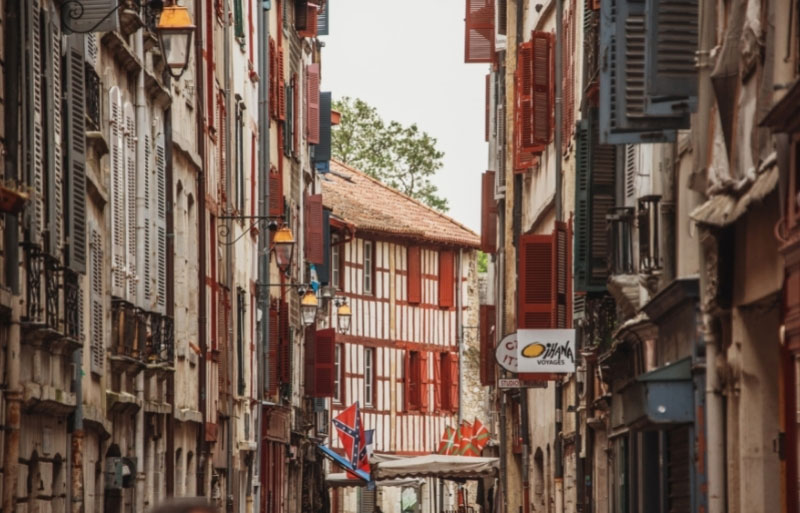 Calle de casas altas y coloridas con entramado de madera en Bayona, País Vasco