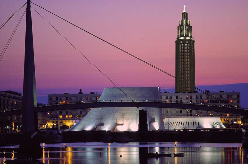 Vista de la ciudad de Le Havre por la noche, monumentos arquitectónicos iluminados contra un oscuro cielo púrpura