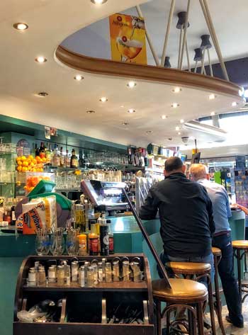 Dentro de una cafetería de los años 50 en Le Havre, un bar con curvas y colores brillantes