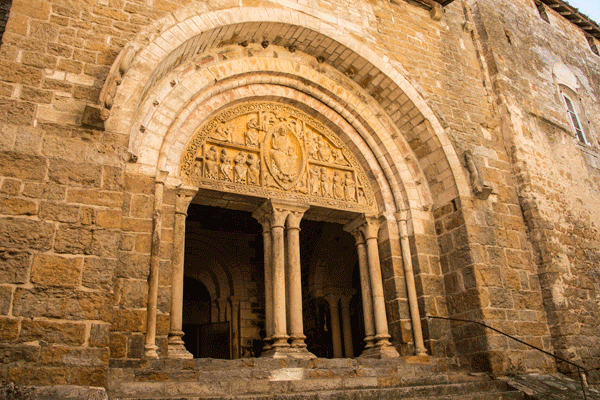 Inmenso y antiguo arco de piedra de una iglesia en Carennac, el Lot