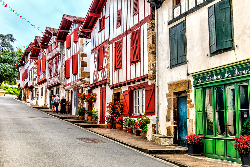 Bonitas casas con entramados de madera de color rojo y blanco en una calle estrecha, Ainhoa, País Vasco