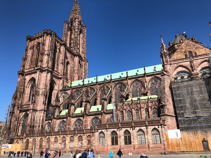 Catedral de piedra roja de Notre Dame de Estrasburgo, el alto campanario es espectacular contra un cielo azul profundo