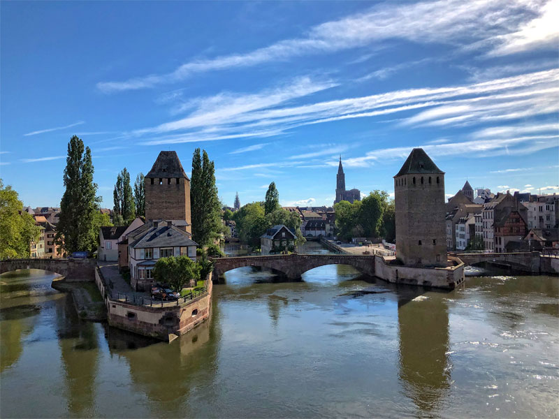 Puente de piedra roja sobre el río Ill, Estrasburgo con altas torres en el puente