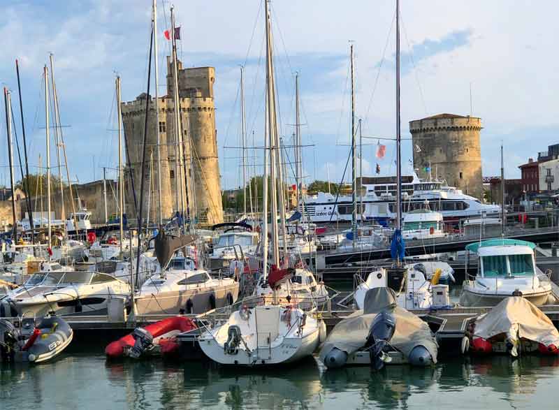 Barcos en el puerto de La Rochelle, altas torres de piedra al fondo