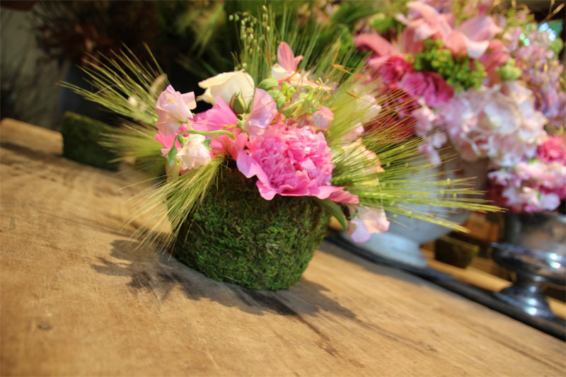 Arreglo floral de flores rosas y pastos verdes en el taller de jardineros del Castillo de Chenonceau