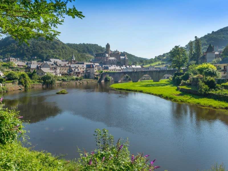 Pueblo al lado de un río, dominado por un antiguo castillo, Estaing en Aveyron, suroeste de Francia