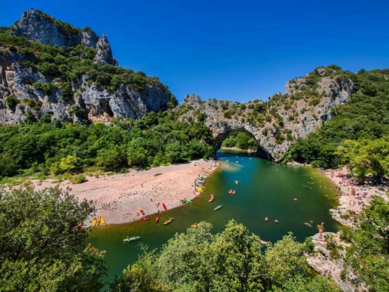 Canoas en el río Ardèche, aguas cristalinas de color verde azulado, un día soleado, rodeado de montañas