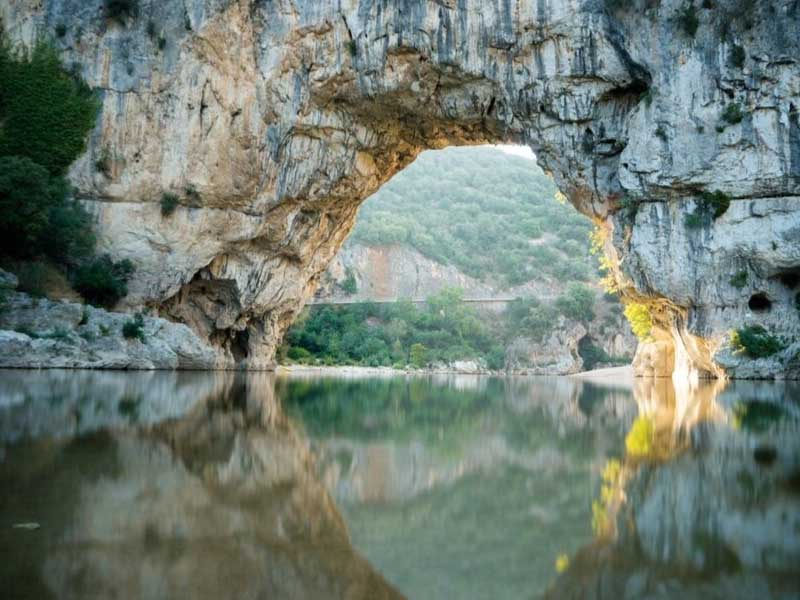 Puente de piedra natural excavado en la roca sobre el río Ardèche