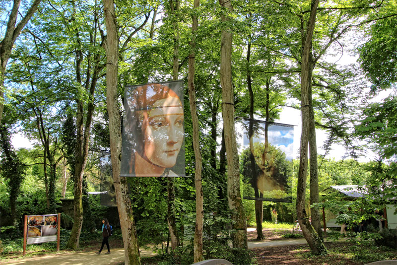 Jardines del chateau du clos luce con grandes imágenes de las famosas obras de Leonardo da Vinci colgadas de los árboles