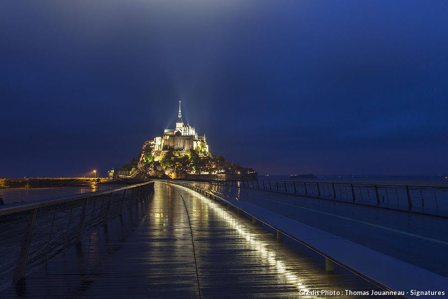 Mont-Saint-Michel y su nueva pasarela de noche. 
