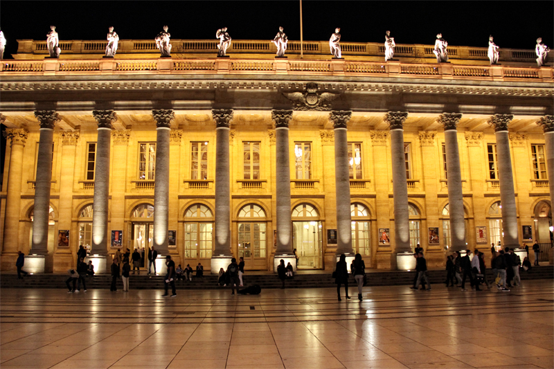 La Gran Ópera de Burdeos, columnas y estatuas se alinean en el frente, iluminadas por la noche