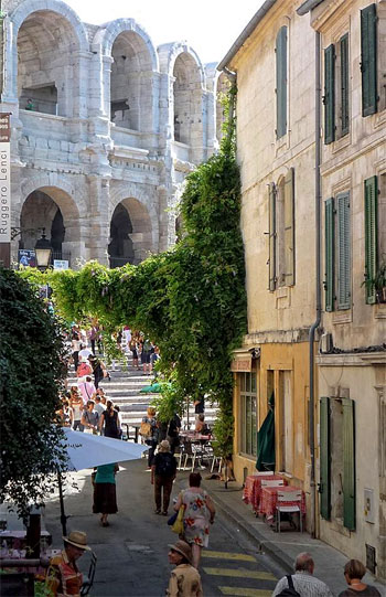 Una pequeña calle conduce a una monumental arena romana en Arles, Provenza
