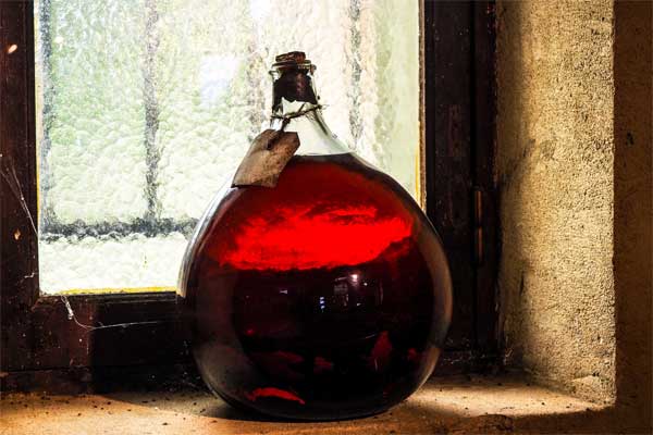 Botella redonda de Armagnac en un alféizar polvoriento en Gascuña, Francia