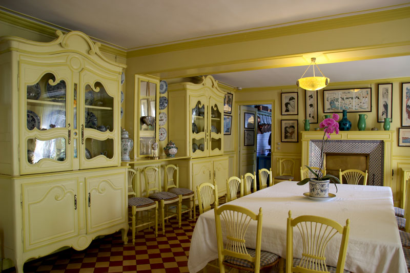 Comedor de la casa normanda de Claude Monet, predominantemente pintado de amarillo