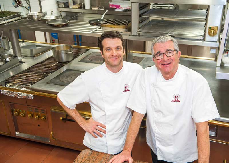 Un viejo y un joven chef posan juntos en su cocina en La Matelote, Boulogne-sur-Mer