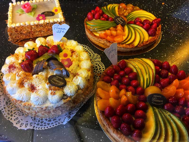Deliciosos pasteles cubiertos con fruta, crema y glaseado en una panadería en Montreuil-sur-Mer