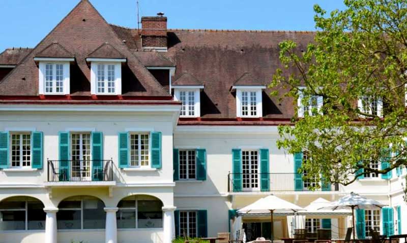 Fachada del hotel Chateau de Montreuil, contraventanas luminosas y arquitectura elegante