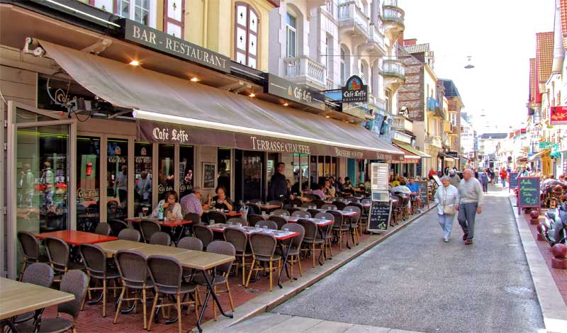 Calle llena de restaurantes y bares, mesas en las aceras en Le Touquet Francia