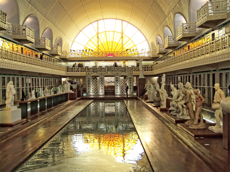Una sala de museo caída de estatuas alrededor de una piscina en Roubaix, Lille