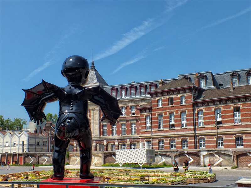 Estatua de un bebé gigante con alas y cola, obra de arte en la Gare Saint Sauveur, Lille
