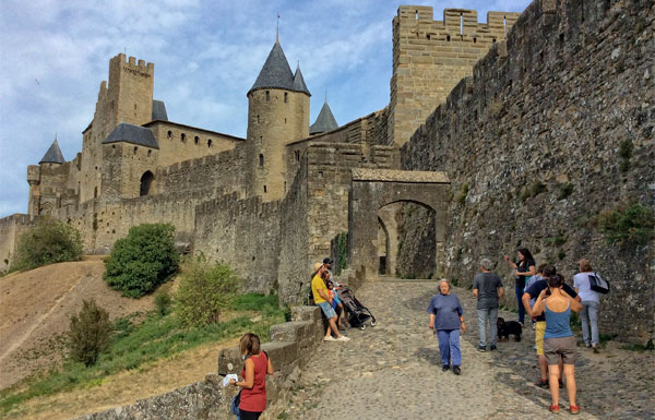 Puerta de piedra arqueada a la antigua ciudad de Carcassonne en la cima de una colina;