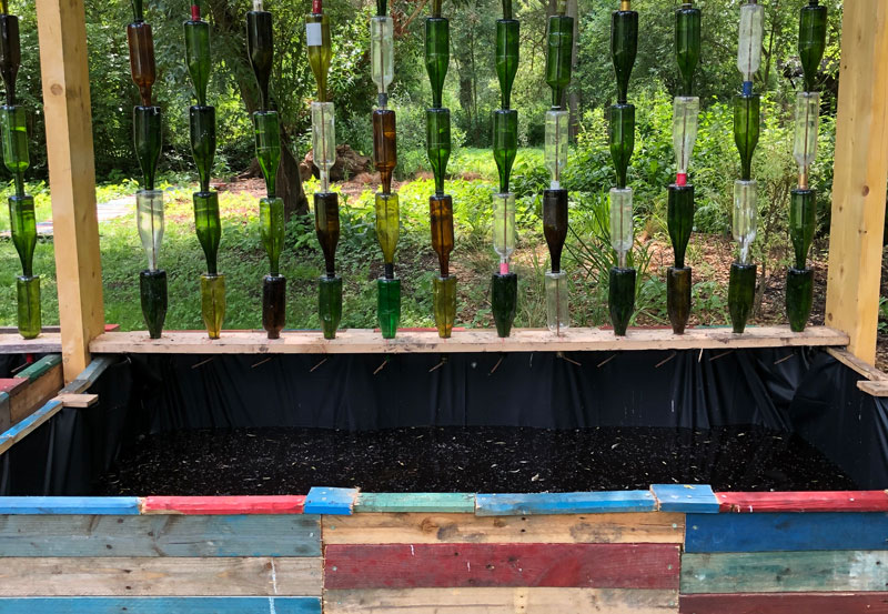 Botellas de vino recicladas utilizadas para recoger agua de lluvia en una instalación de arte en Amiens, Francia
