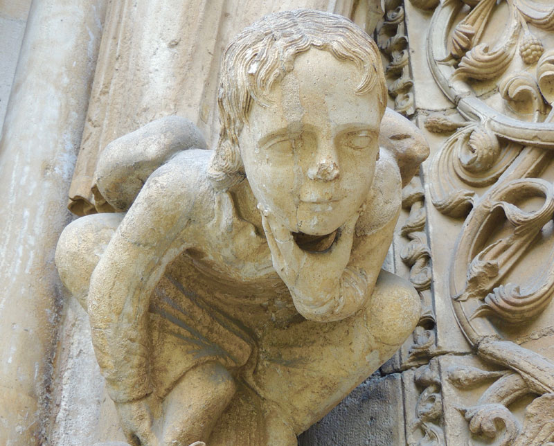 Antigua talla de piedra de Saint Denis, llevando su propia cabeza, según cuenta la leyenda, en la Basílica de Saint-Denis, París