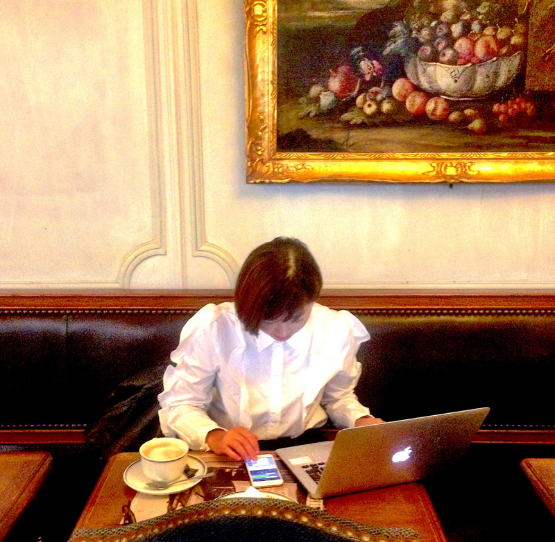 A woman sits in a cafe in Paris using the Wi-Fi
