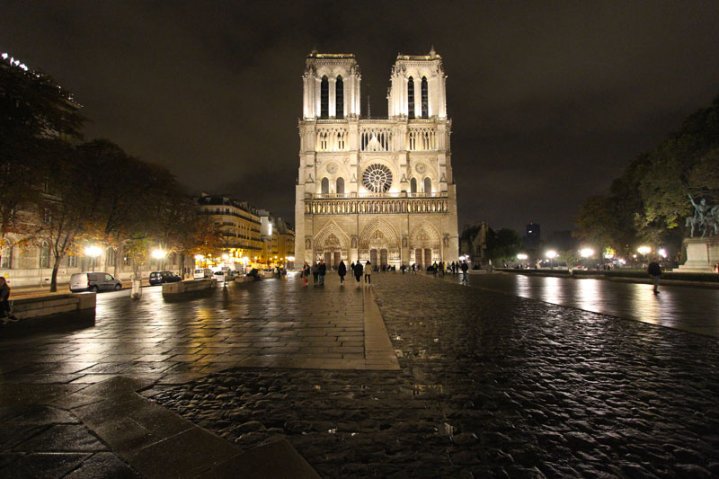 Notre Dame Cathedral at night, the iconic bell towers lit up against a dark sky