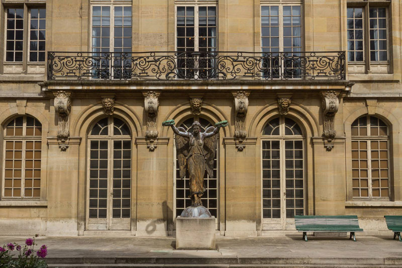 Stone facade of a grand mansion house in Paris with wrought iron balcony, now Musee Carnavalet