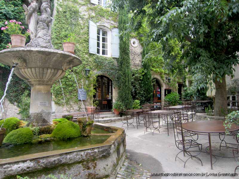 Pretty courtyard with a tinkling fountain in the middle in Saignon, Provence